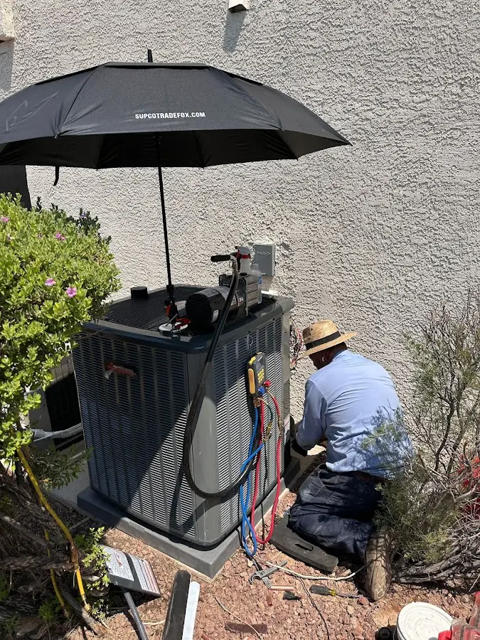 HVAC technician performing outdoor AC maintenance in Elon